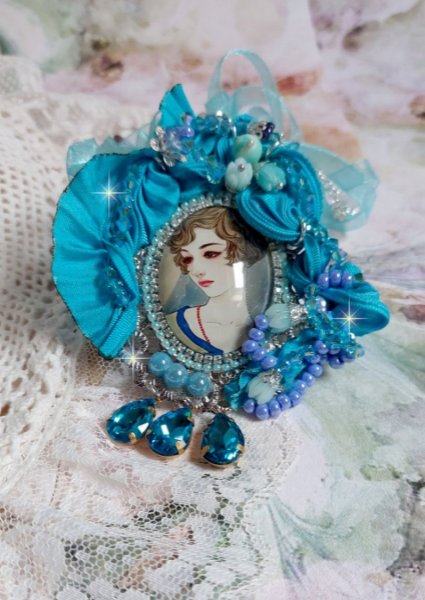 Pendentif Mademoiselle au style r&eacute;tro avec cabochon d&rsquo;une femme souriante, orn&eacute; d&rsquo;un ruban de soie Bleu, cristaux, perles verre : rocailles et roses, coupelles et cha&icirc;ne Argent 925/1000