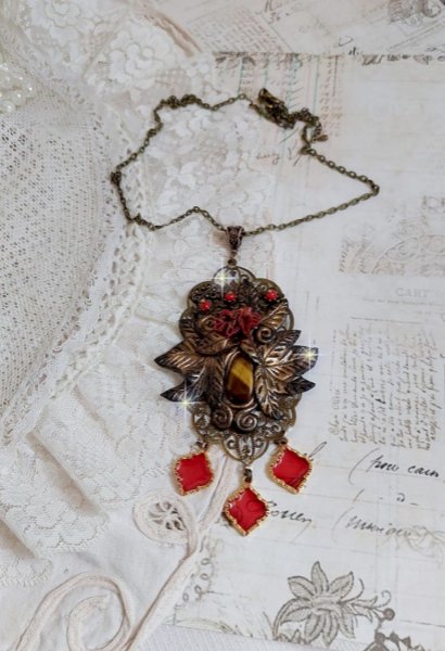 Pendentif M&eacute;lodie avec un cabochon &OElig;il de tigre orn&eacute; de perles en Jade Rouge vein&eacute; de Noir sur fleurs 5 p&eacute;tales et estampes mont&eacute;s sur une cha&icirc;ne bronze. Les pendants sont en r&eacute;sine &eacute;poxy Rouge