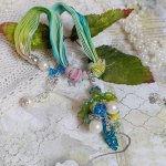 Collier Regard Scintillant créé avec fleurs acryliques, ruban de soie, chaîne en argent et perles Cristal Swarovski