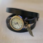 Relógio bracelete de couro com encantos de penas e pérolas