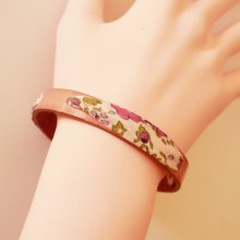 Pulseira Florâme com fita liberty e flores roxas em pele rosa envelhecida