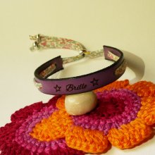 Pulseira Florâme 'Brille' gravada com fita liberty em tons pastel sobre pele roxa