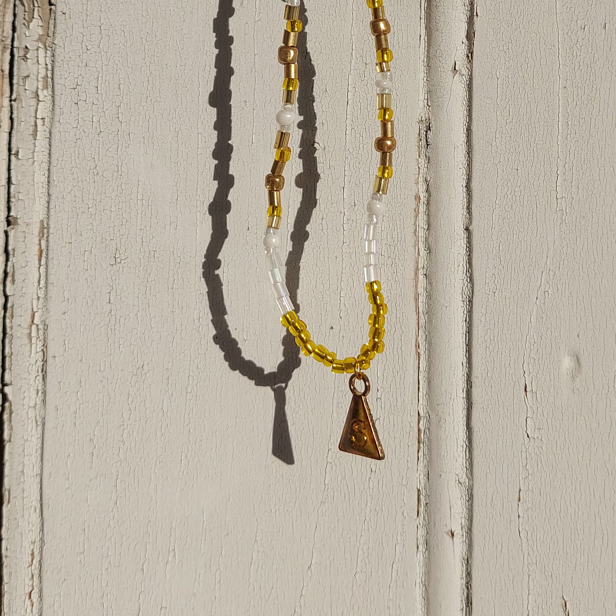 Ras du cou dor&eacute;, blanc, et breloque : Soleil